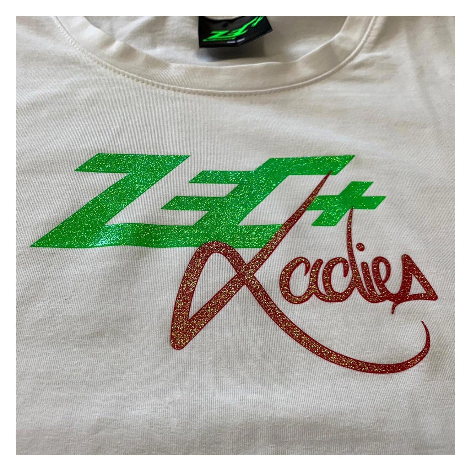 Detailansicht Vorderseite, grünes Zec+ Logo mit rotem Glitter-Schriftzug Ladies